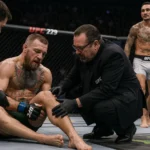 Conor McGregor knee injury assessed by cageside doctor as referee looks on and Max Holloway walks past in the background.