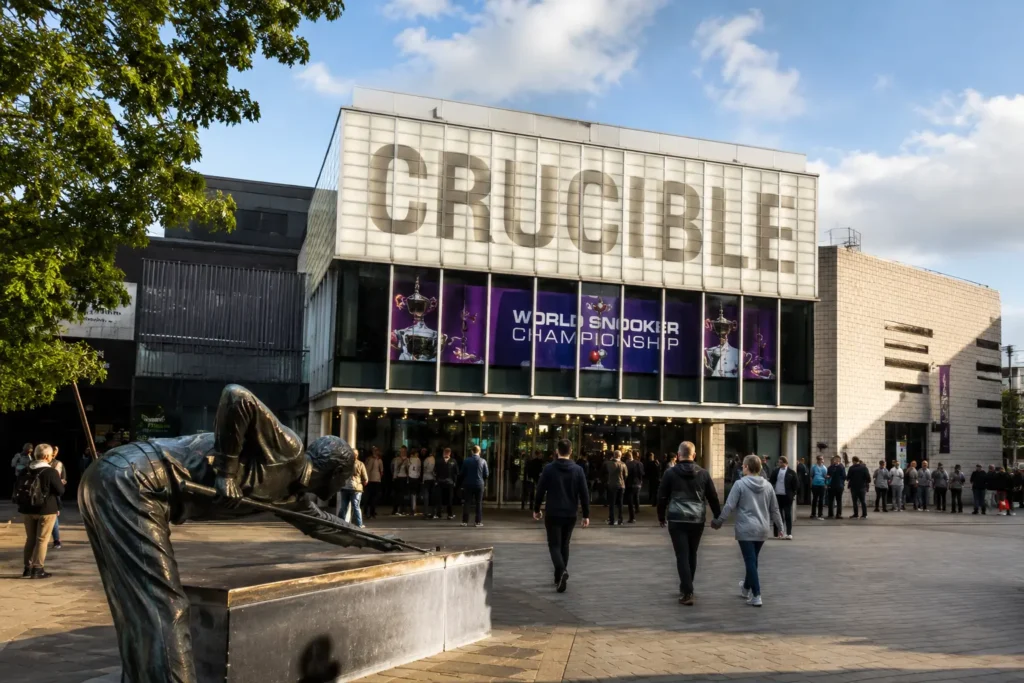 Crucible World Snooker Championship banner above the Crucible Theatre entrance in Sheffield, with fans queuing outside and the snooker player statue in Tudor Square