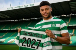 Oxlade-Chamberlain signs Celtic deal, holding a Celtic shirt with "Chamberlain 2027" at Celtic Park